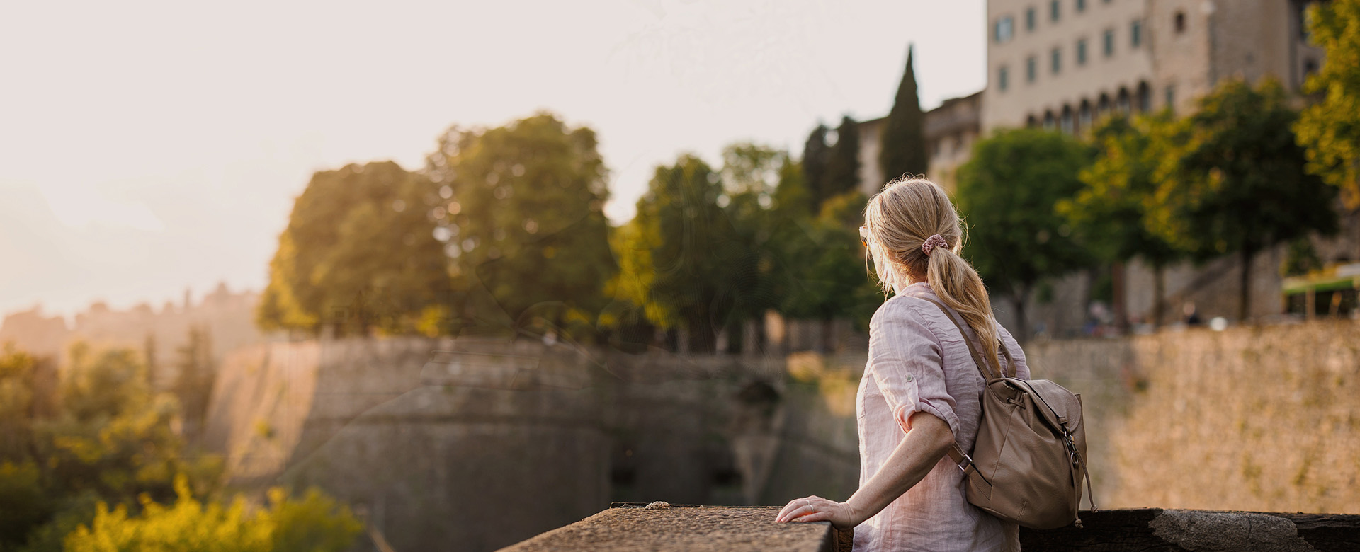 Turistka si vychutnáva výhľad na mestské hradby.