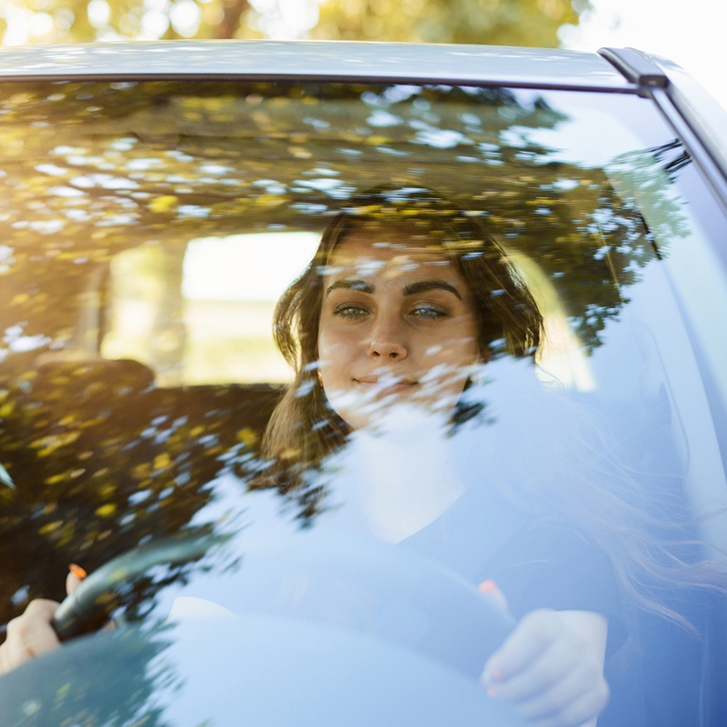 A woman behind the wheel in a car.