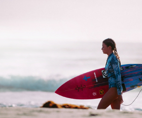 zena pri mori s padleboardom 