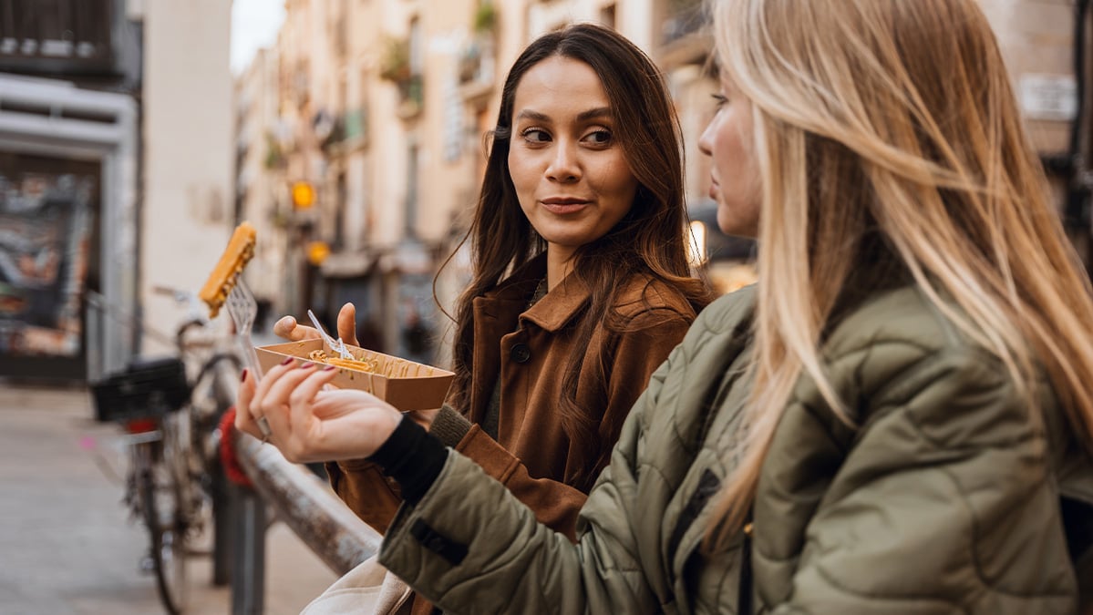 Kamarátky na dovolenke si vychutnávajú cenovo dostupný street food.