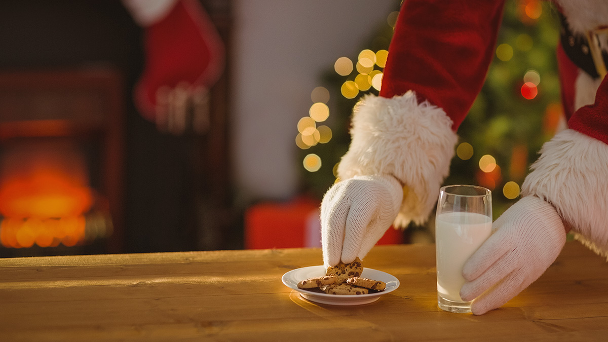Santa Claus si zo stola berie sušienky a mlieko, ktoré preňho pripravili deti.