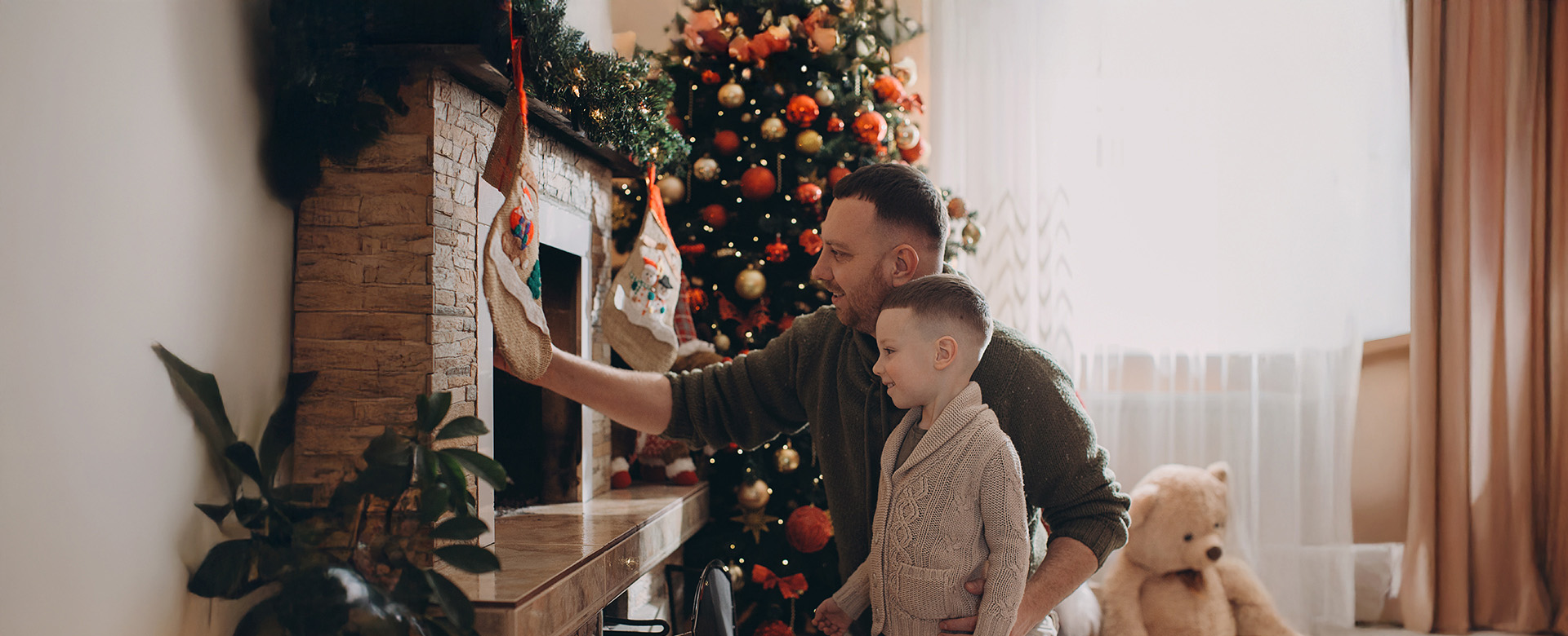 Otec so synom pripravujú nad krb ponožky pre Santa Clausa.