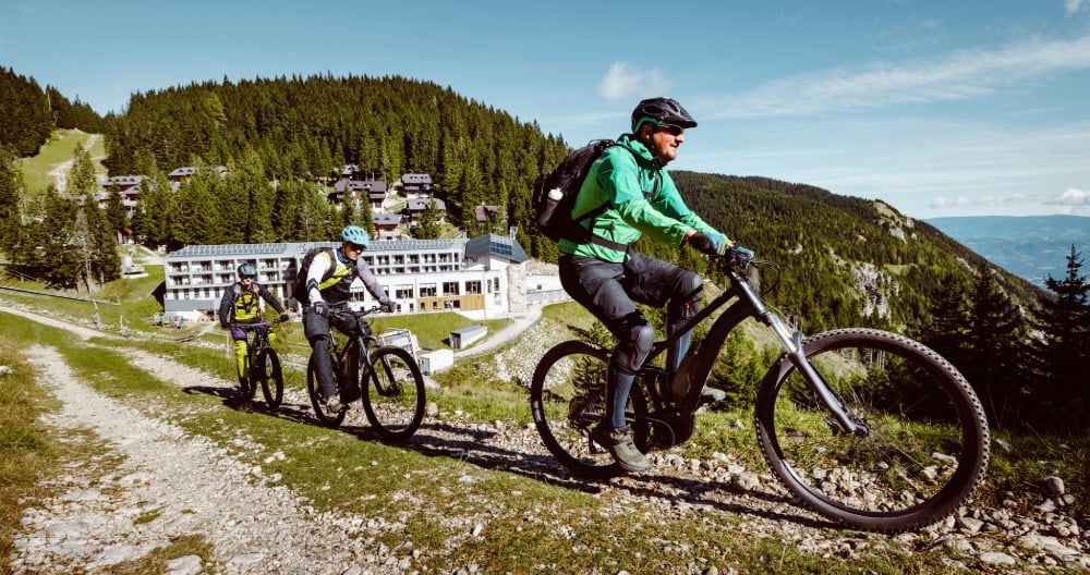 Traja muži na bicykloch v horách.