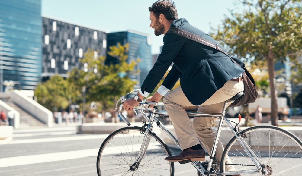Muž bicykluje v meste.