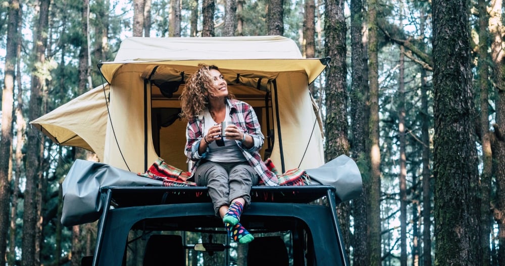 Žena sedí v stane upevnenom na aute.