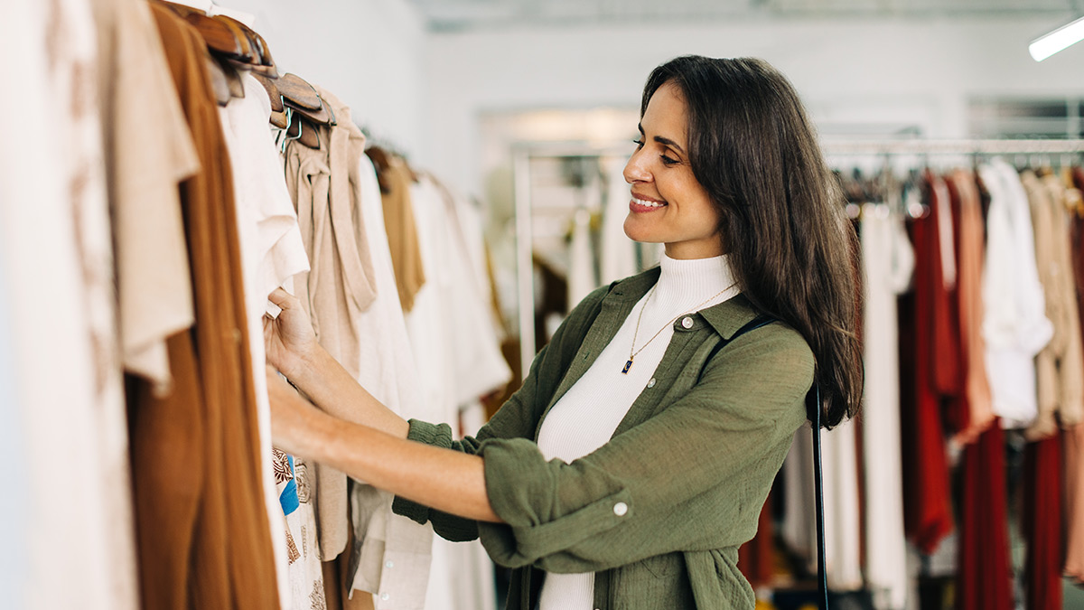 Zákazníčka prehliadajúca si oblečenie v obchode.