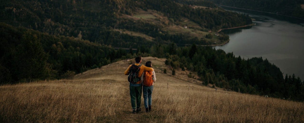 Pár vychutnávajúci si pokojnú prechádzku v prírode.
