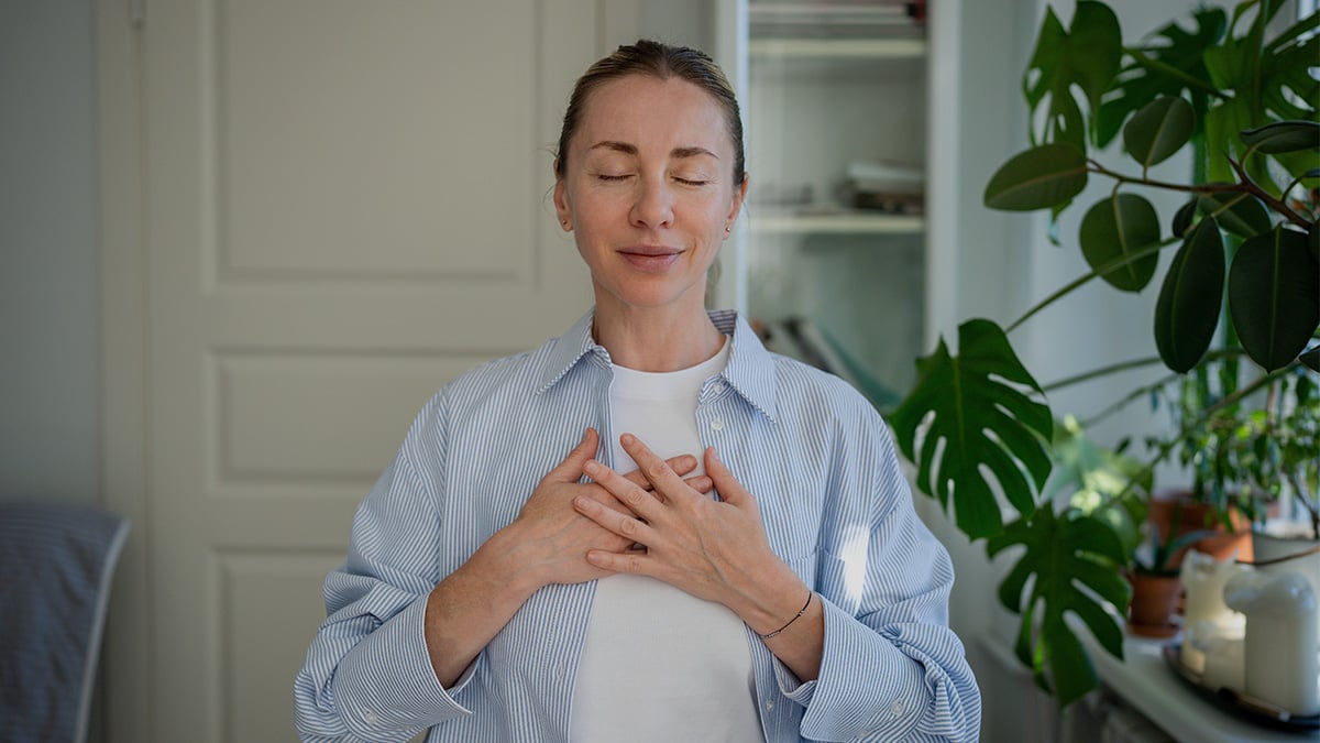 Žena venujúca sa dychovému cvičeniu v domácom prostredí.