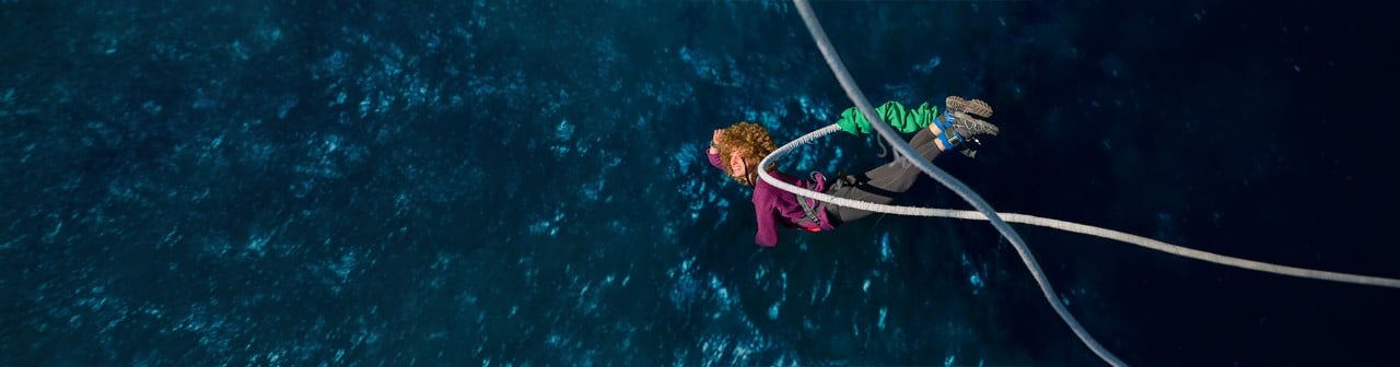 Žena skáče bungee jumping nad vodou