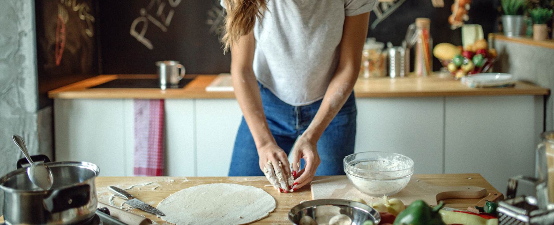 Žena v kuchyni pripravuje jedlo s múkou.
