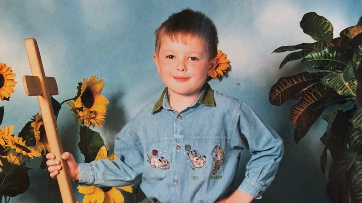 Mladý Martin Joppa, ako dieťa, pózuje na milú fotku so slnečnicami.