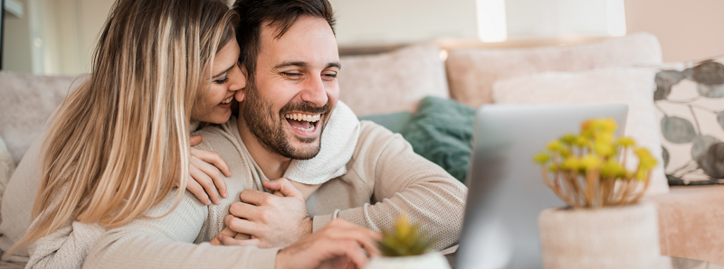 zena objima muza, pozeraju do pocitaca a su stastni