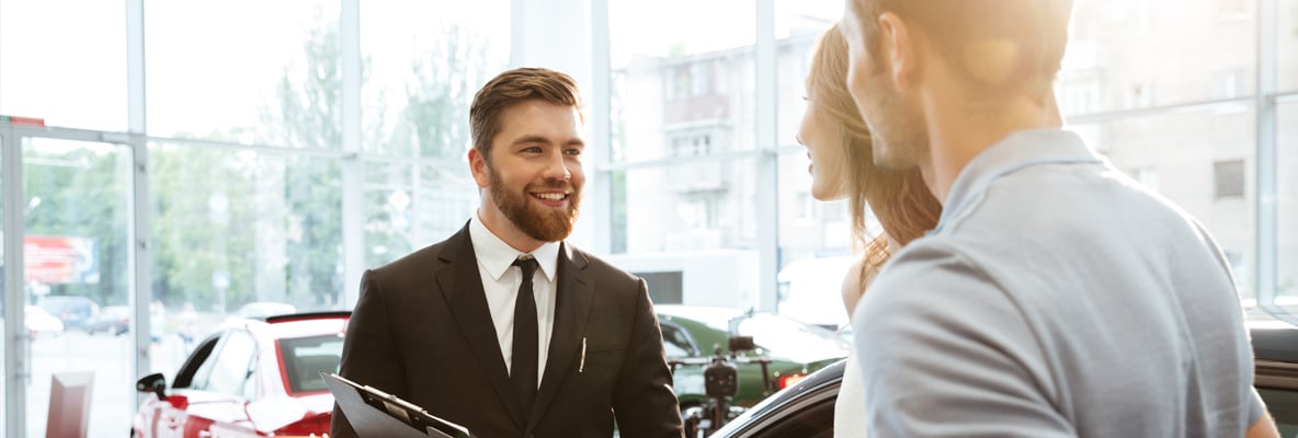 predajca v autosalone s klientmi