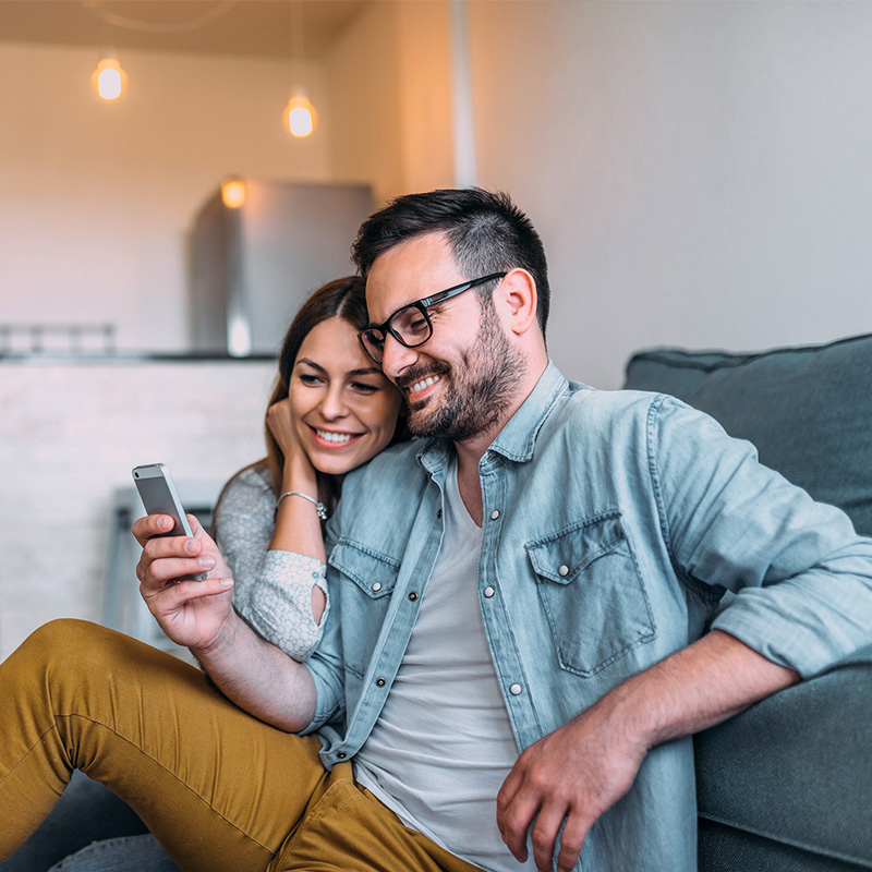 muz sa pozera do mobilu, vedla neho sedi zena