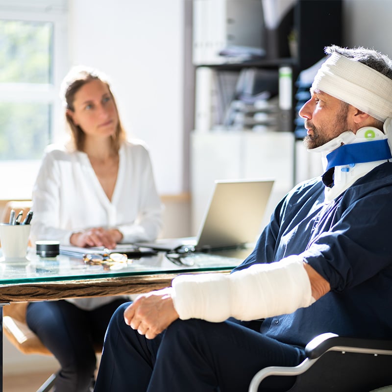 pacient s poranenou hlavou a rukou u lekára