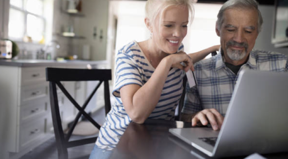 muž a žena pozerajú do notebooku