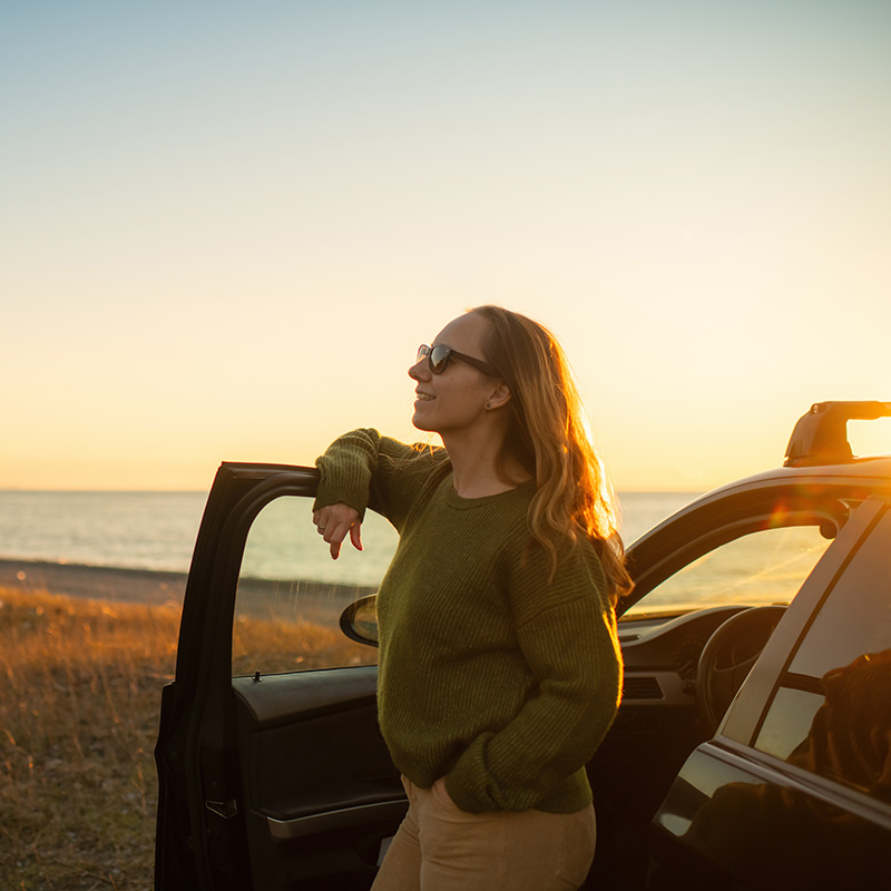 zena stoji pri otvorenych dverach auta