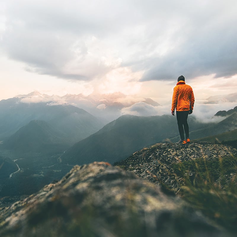 muž stojaci na kopci a pozerajúci sa do diaľky