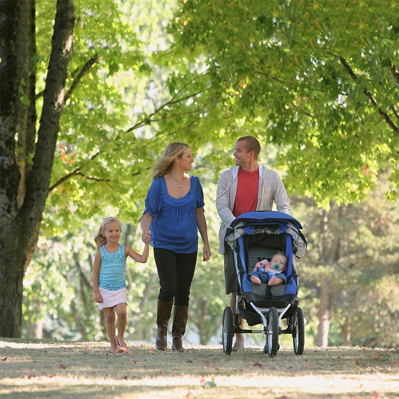 rodinka na prechádzke, rodicia, dcéra a dieťa v kočíku