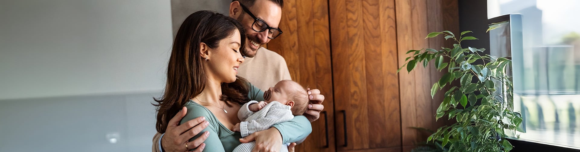 šťastný a umievajúci sa otec s mamou, mama má v naručí novonarodené dieťa