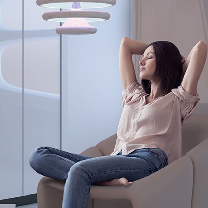 zena relaxuje v kresle, ruky ma za hlavou, oci zatvorene