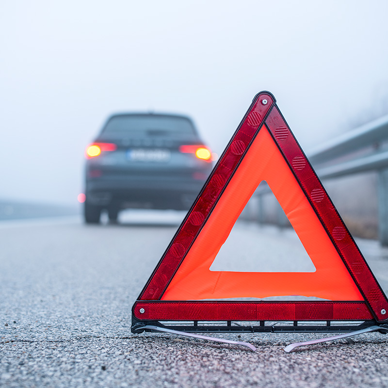 auto na ceste s vystraznym trojuholnikom